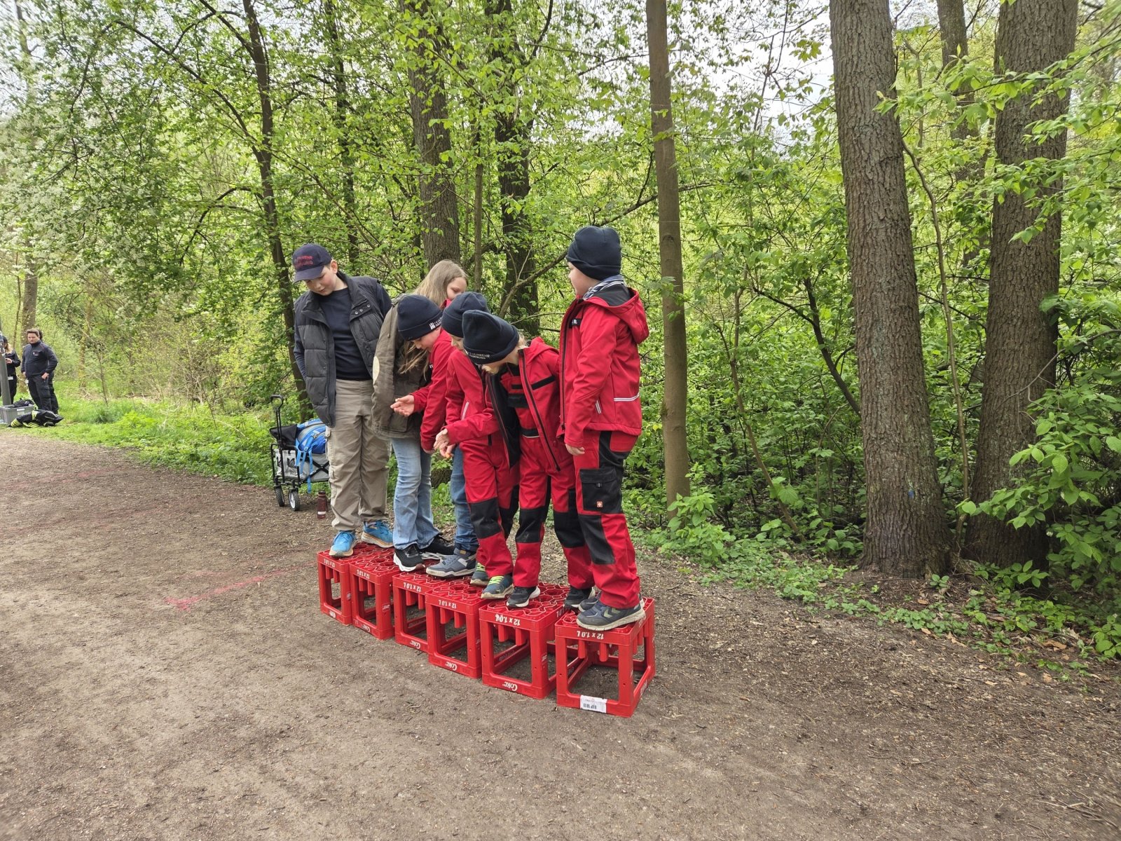 Balancieren auf Getränkekisten beim Ausflug in den Wald